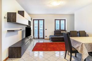 a living room with a dining room table and a couch at Appartamento Cles in Cles