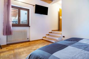 a bedroom with a bed and a tv on the wall at Appartamento Cles in Cles