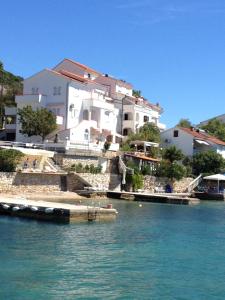 a group of buildings on the shore of a body of water at Apartments Villa Emilija in Supetarska Draga