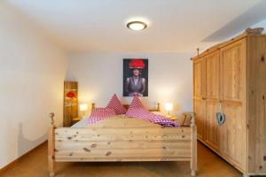 a bedroom with a wooden bed with a painting on the wall at Haus Winterberg in Schonach