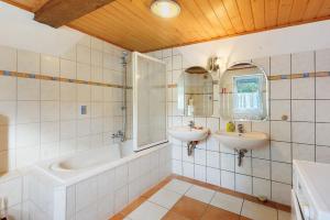 a bathroom with two sinks and a tub and a mirror at Scholz in Sannerz +14 photos