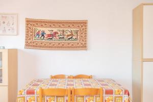 a table with two chairs and a picture on the wall at Flat Orizzonte in Palau