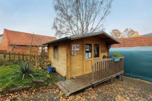 a small wooden cabin with a porch in a yard at Scholz in Sannerz
