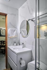 a white bathroom with a sink and a mirror at Pacohouse, Apartamento cerca al parque in Jardin +10 photos