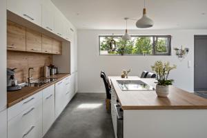 a kitchen with white cabinets and a wooden counter top at Ferienwohnung im Obstgarten in Ihringen
