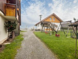 a gravel road in front of a house and a yard at Obsthof Mainberger in Kressbronn am Bodensee