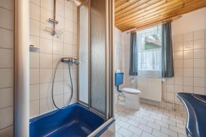 a bathroom with a blue tub and a toilet at Ferienhaus Bergmannsruh in Clausthal-Zellerfeld +14 photos