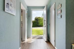 an open door into a hallway with a view of a yard at Feriendoppelhaus Sommer in Stakendorf
