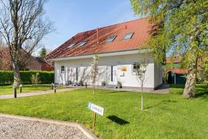 a house with a sign in the front yard at Feriendoppelhaus Sommer in Stakendorf