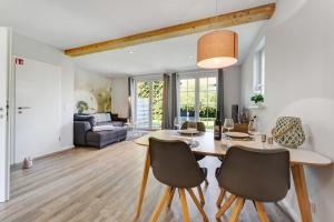 a dining room and living room with a table and chairs at Feriendoppelhaus Sommer in Stakendorf