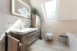 a bathroom with a sink and a toilet and a window at Feriendoppelhaus Sommer in Stakendorf +20 photos