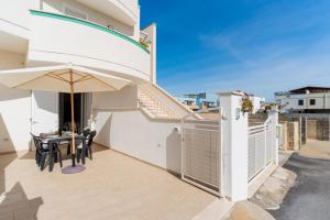 a patio with a table and an umbrella at Casa d'a mare in Torre San Giovanni Ugento