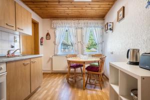 a kitchen with a table and chairs and a window at Ferienhaus Bergmannsruh in Clausthal-Zellerfeld