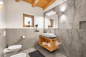 ein Badezimmer mit weißer Toilette und Waschbecken in der Unterkunft Maierhof in Wengen + 82 Fotos
