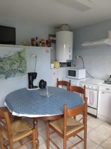 a kitchen with a table and some chairs and a table and a kitchen at Chambres Paysannes Lecarpentier - in Fontenay