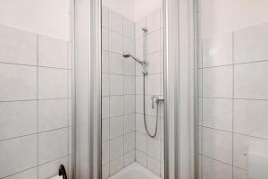 a bathroom with a shower with white tiles at Krüseliner Mühle - Appartements in Krüselin +38 photos