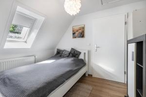 a bedroom with a bed and a chandelier at Ferienhaus Magda in Stadum
