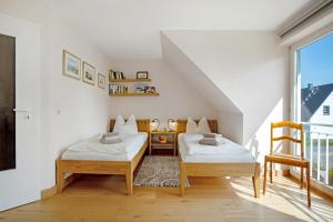 two beds in a small room with a balcony at Haus Schilfblick in Wieck