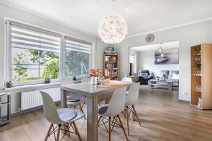 a dining room and living room with a table and chairs at Ferienhaus Magda in Stadum +19 photos