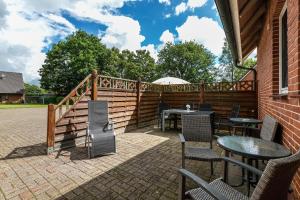 a patio with tables and chairs and a fence at Ferienhaus Magda in Stadum