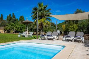 a swimming pool with chairs and an umbrella at Les Herbetes in Port de Pollensa