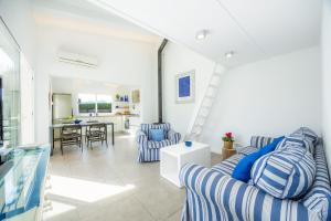 a living room with blue and white striped couches at Les Herbetes in Port de Pollensa