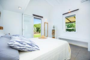 a white bedroom with a bed and a window at Les Herbetes in Port de Pollensa +24 photos