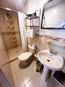 a bathroom with a sink and a toilet and a mirror at Inca Wasi Plaza de Armas in Cusco