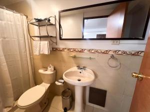 a bathroom with a sink and a toilet and a mirror at Inca Wasi Plaza de Armas in Cusco