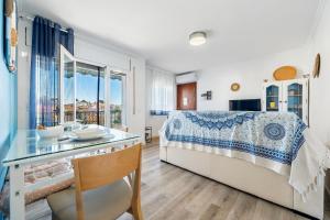 a bedroom with a bed and a desk with a glass table at Apartamento Paul in Torredembarra