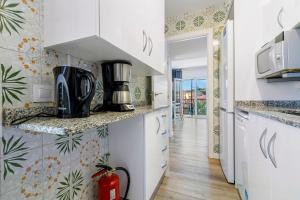 a kitchen with white cabinets and a counter top at Apartamento Paul in Torredembarra +12 photos