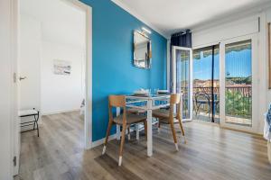 a dining room with blue walls and a table with chairs at Apartamento Paul in Torredembarra