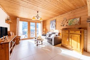 a living room with a couch and a table at Tié No Appartement Chaleureux in Manigod