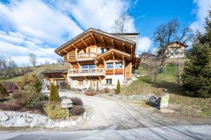 a large wooden house on a hill at Tié No Appartement Chaleureux in Manigod