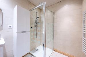 a shower with a glass door in a bathroom at Tié No Appartement Chaleureux in Manigod +25 photos