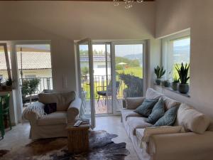 a living room with couches and a view of a patio at Casa Tapeo in Schiefling am See +8 photos