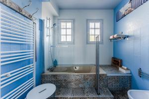 a blue bathroom with a tub and a toilet at Chambre D'hote Chez Amaya in Gujan-Mestras