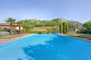 a large blue swimming pool with a mountain in the background at Apartment Jose in Tremosine Sul Garda