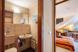 a bathroom with a sink and a bed in a room at Ferienwohnung Weitblick in Bad Liebenzell +25 photos