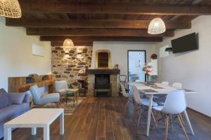a living room with a table and chairs and a fireplace at Maison de vacances Kerkohann in Tressignaux