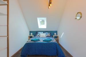 a bedroom with a bed with a blue comforter at Maison de vacances Kerkohann in Tressignaux