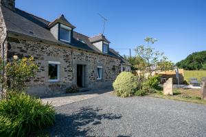 a stone house with a driveway in front of it at Maison de vacances Kerkohann in Tressignaux