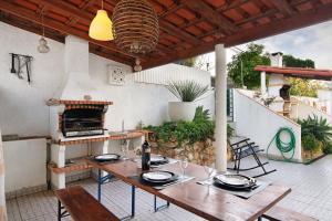 a patio with a table and a fireplace at Lemons Apartment in Carvoeiro