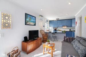 a living room with a couch and a tv at Lemons Apartment in Carvoeiro
