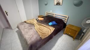 a bed with a brown blanket and a blue pillow at Lemons Apartment in Carvoeiro
