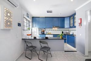 a kitchen with blue cabinets and two chairs at Lemons Apartment in Carvoeiro +15 photos