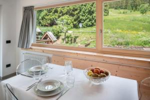 a table with a bowl of fruit and a window at Apart Wellness Alpino con minispa in Soraga +30 photos