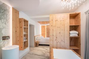 a room with a wooden partition with a bed at Apart Wellness Alpino con minispa in Soraga