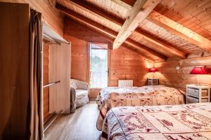 a bedroom with two beds in a log cabin at Chalet Marmottes in Morillon