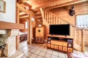 a living room with a large television in a cabin at Chalet Marmottes in Morillon